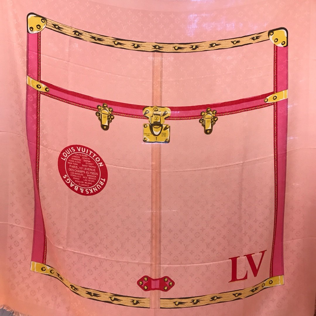 Louis Vuitton 行李箱方巾 140*140cm 60%真丝40%羊毛 此款由真丝与羊毛裁制而成的夏日披肩印有视幻风格的旅行箱图案，其中的Louis Vuitton旅行箱吊牌、黄铜铰链与包角等细节元素色泽鲜润，栩栩如生。浅粉色Monogram背景