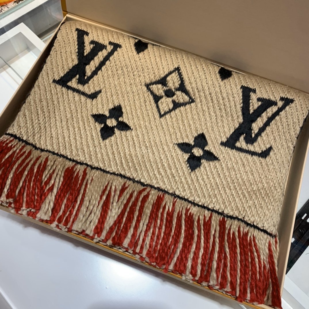 Louis Vuitton 双层毛线围巾 39^180cm 84%羊毛16%真丝 在柔软哑光羊毛与闪光涂层真丝构筑的两式风尚之间自如切换。提花织纹重塑全幅 Monogram 图案，点缀流苏饰边，大尺寸设计为寒冷天气带来柔和暖意